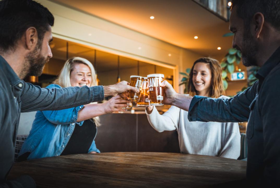 A group of friends joining glasses in a 'cheers!' motion.